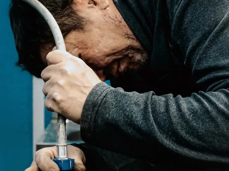 Technician fitting a water line connection
