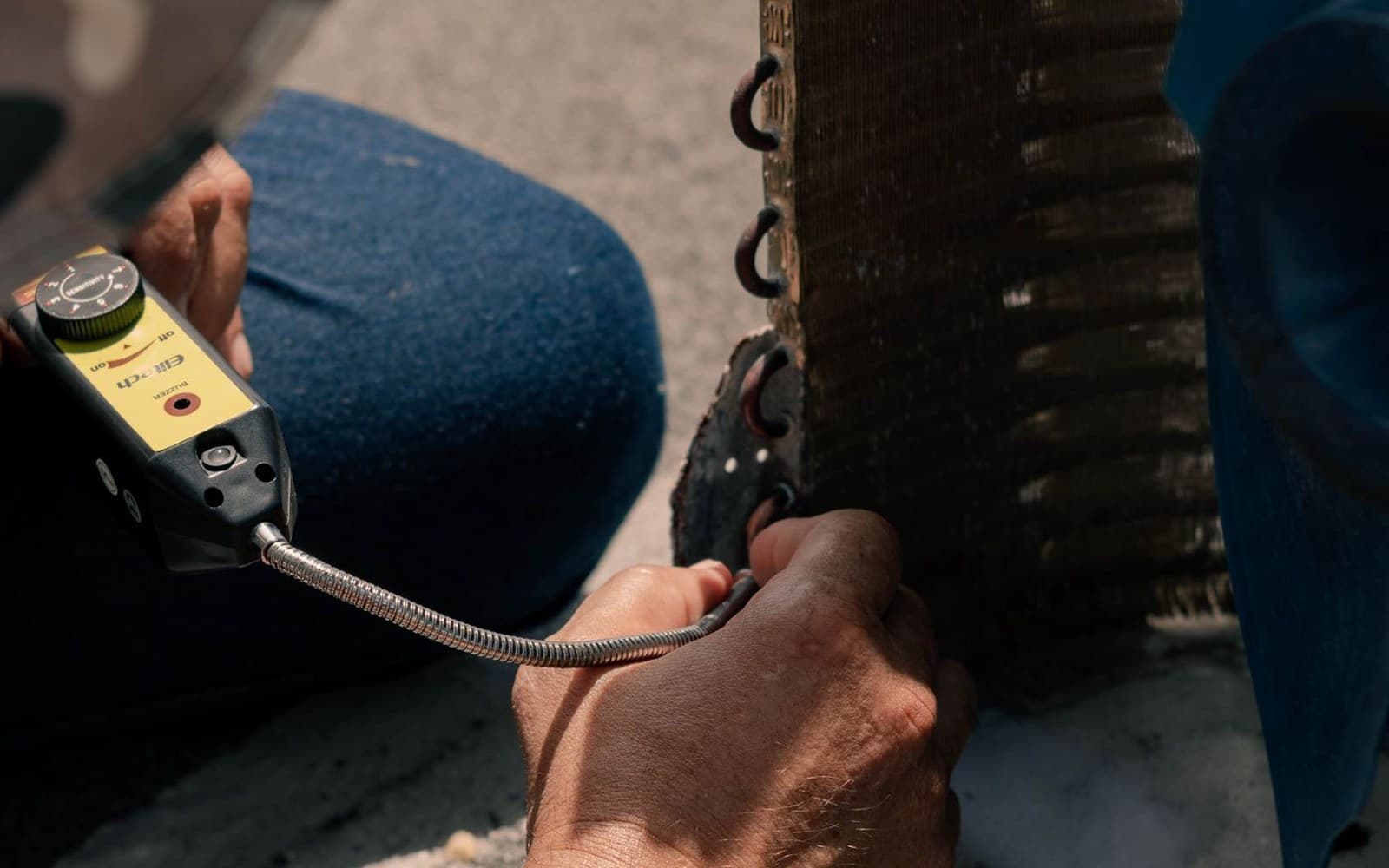 Technician servicing an outdoor HVAC condenser unit